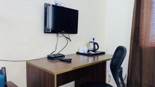 a desk with a television on top of a room at LivBox in Rāmpura