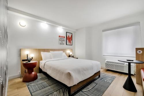 Un dormitorio con una cama grande y una mesa. en BOB Hotels Tallahassee - Boutique on Budget, en Tallahassee