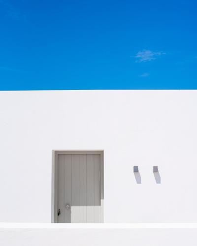 a door in a white building with a blue at CAMPO SUITES in Kampos Paros
