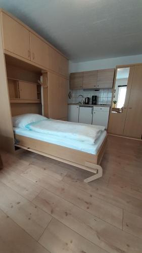 a large bed in a room with a kitchen at 1-Zimmer-Apartment-1-im-1-Obergeschoss in Lübeck