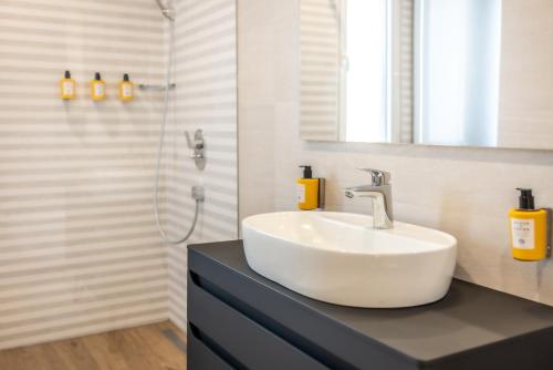 a bathroom with a sink and a shower at Apeiro City Avant-garde Hotel in Sarajevo