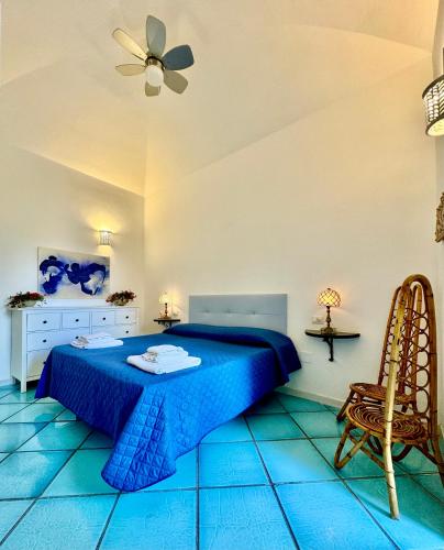 a bedroom with a blue bed and a chair at La Casa di Bubi in Anacapri