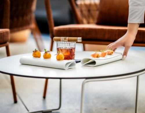 a table with a drink and food on it at Apeiro City Avant-garde Hotel in Sarajevo