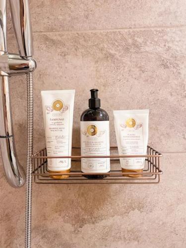 a shelf with three bottles of soap on it at Charming Rustic Beach House Hideaway in Klaipėda