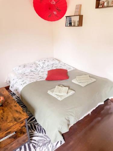 a bed in a room with a red clock on the wall at Charming Rustic Beach House Hideaway in Klaipėda