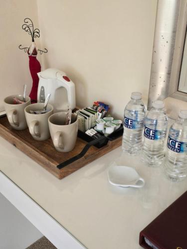 a counter with a tray with cups and bottles of water at Chilton Villa B&B in Sandwich