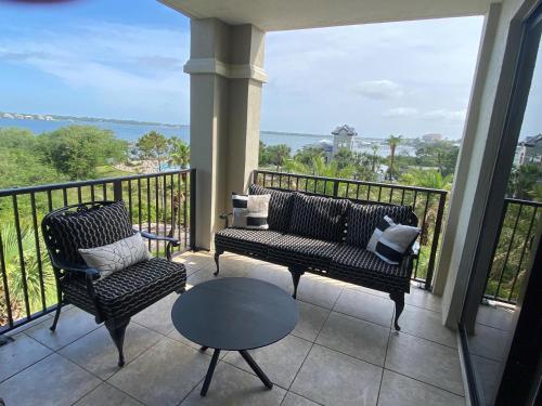 a balcony with two chairs and a couch and a table at Florencia #207 in Perdido Key