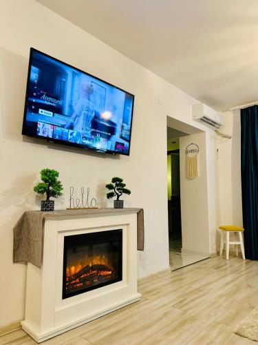 a living room with a fireplace and a flat screen tv at BB Apartaments Dream Village in Iaşi