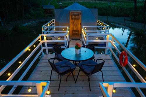 a table and chairs on a deck at night at Bunkier House in Niedźwiada