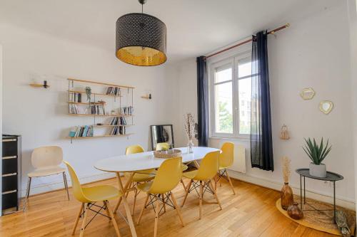 une salle à manger avec une table blanche et des chaises jaunes dans l'établissement Chaleureux et Cosy avec garage privé, à Villeurbanne