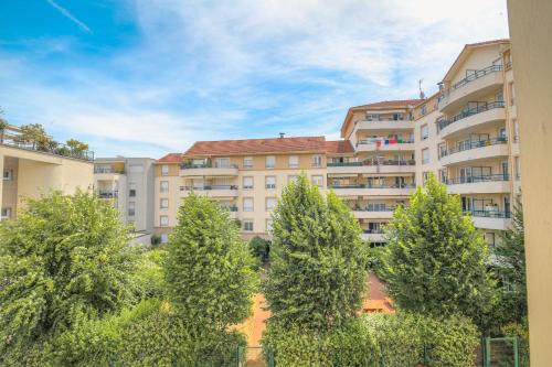 un groupe d'arbres devant un bâtiment dans l'établissement Chaleureux et Cosy avec garage privé, à Villeurbanne