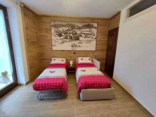 two beds in a room with wooden walls at Ca' d'la Mamaa in Craveggia