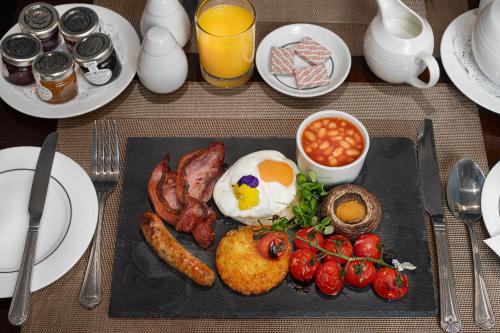 a breakfast plate with eggs bacon beans and tomatoes at Gem Fitzrovia Hotel in London