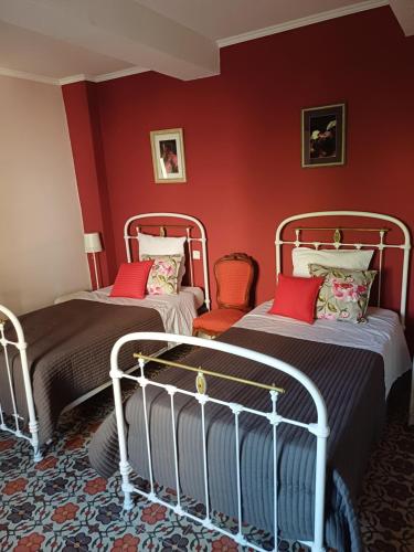 two beds in a room with red walls at No2 La Place in Tourbes