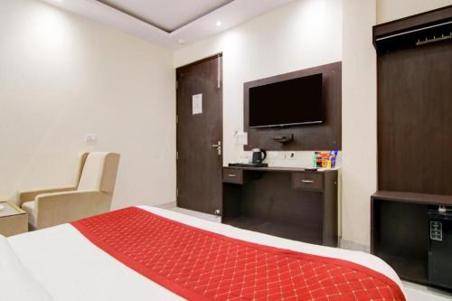 a hotel room with a bed and a desk with a television at Hotel De Hocks Deluxe - New Delhi Railway Station in New Delhi