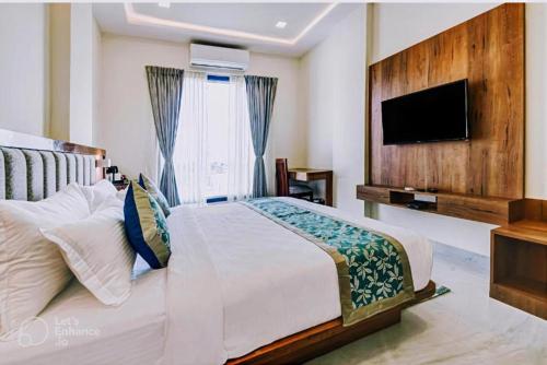 a bedroom with a large bed and a flat screen tv at Hotel De Hocks Deluxe - New Delhi Railway Station in New Delhi