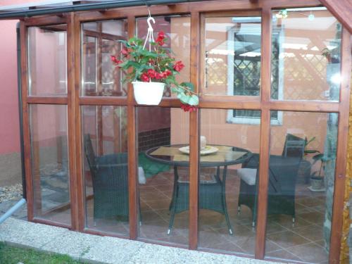 a glass greenhouse with a table and a potted plant at Apartments České Středohoří in Teplice