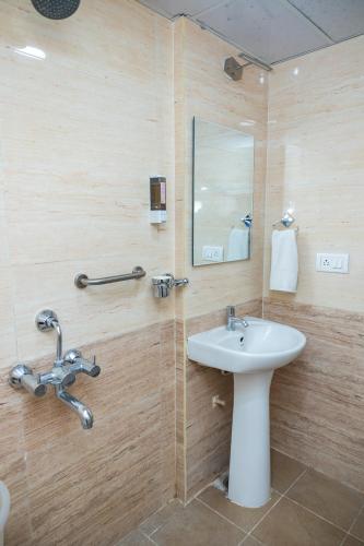un baño con lavabo y espejo en Ishwerya Suites, en Bangalore