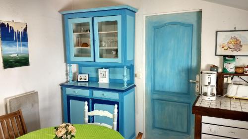 une armoire bleue dans une salle à manger avec une table dans l'établissement Logement cosy proche gare avec terrasse de verdure, à Saumur