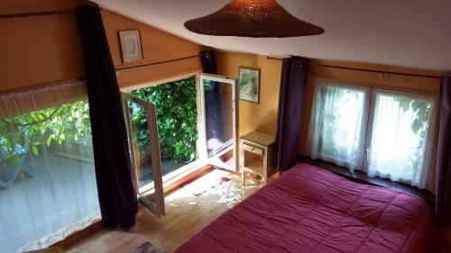 une chambre avec un lit violet et une fenêtre dans l'établissement Logement cosy proche gare avec terrasse de verdure, à Saumur