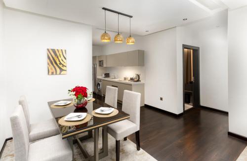 a dining room and kitchen with a table and chairs at The Address Serviced Apartments in Al Khobar