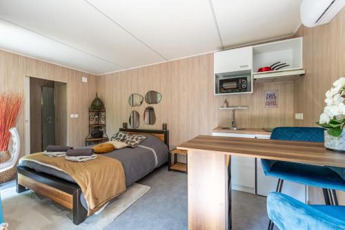 a bedroom with a bed and a table and a kitchen at Chambre d'hôtes de la dame blanche in Borrèze
