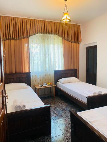 a bedroom with two beds and a window at Berat Feeling Guesthouse in Berat
