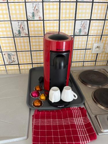 une cafetière rouge assise au-dessus d'un comptoir dans l'établissement Jardins Amélie, à Strasbourg