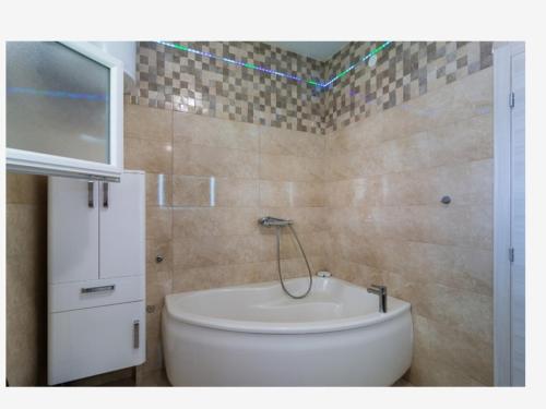 a bathroom with a tub and a toilet in it at DoMiNi in Selca