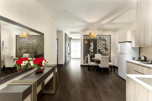 a kitchen and dining room with tables and chairs at The Address Serviced Apartments in Al Khobar