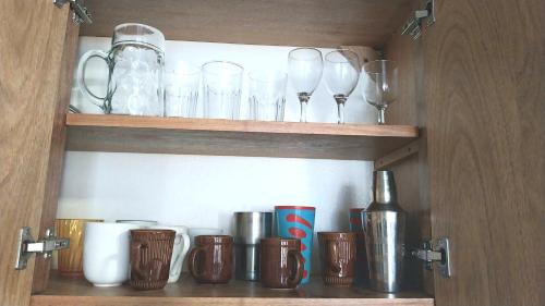 a cupboard with glasses and other items on it at The biggest swimming pool in Sosua, frente a la piscina más grande en sosua in Sosúa