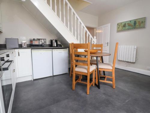 a kitchen with a table and chairs and a staircase at 3 Cowper Place in Clitheroe