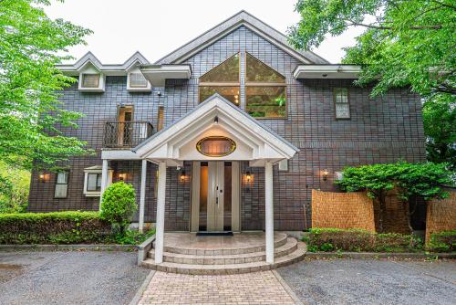 a brick house with a front door and a porch at 大室山の角 in Ito