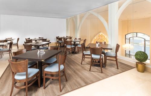a restaurant with tables and chairs and a window at The Address Serviced Apartments in Al Khobar