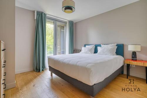 une chambre avec un grand lit et une fenêtre dans l'établissement Le Vital - À Auteuil - 358B, à Paris
