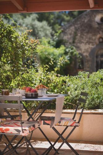 een tafel en stoelen met een fruitschaal erop bij Bastide Sainte Trinide in Sanary-sur-Mer