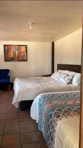 a bedroom with two beds and a painting on the wall at La Villafranca del Cid in Zitácuaro