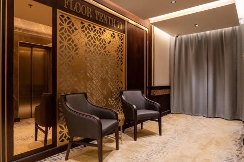 a waiting room with two chairs and a elevator at The Address Serviced Apartments in Al Khobar