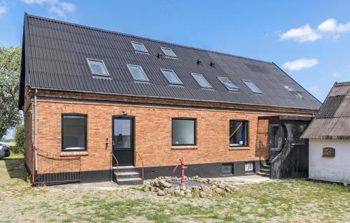 a large brick building with a black roof at 5 Bedroom Awesome Home In Gudhjem in Gudhjem