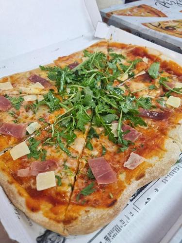 a pizza with ham and greens on a box at Boat Haus - Casas Flotantes frente a Gibraltar in La Línea de la Concepción