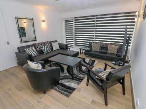a living room with a couch and a table and chairs at 34 Croft Court in Tenby