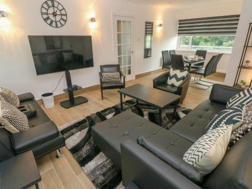 a living room with a couch and a tv at 34 Croft Court in Tenby