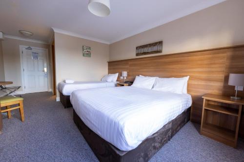 a hotel room with two beds and a desk at Riverside Hotel in Sligo
