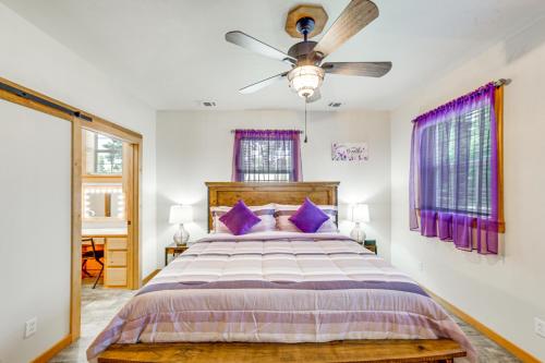 a bedroom with a large bed with purple pillows at Quitman Lakefront Cabin with Screened Porch and Grill! in Quitman