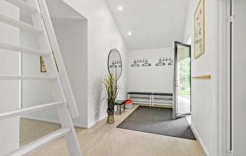a white hallway with a staircase and a mirror at 5 Bedroom Awesome Home In Ebeltoft in Ebeltoft