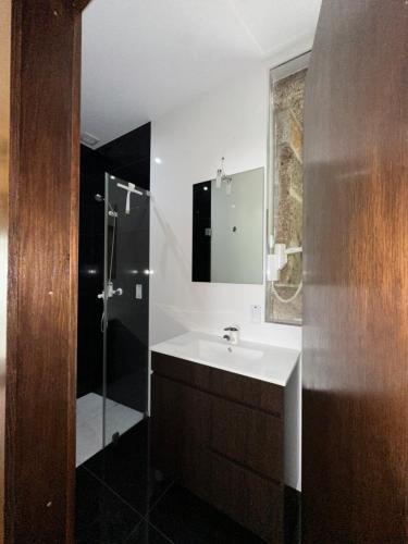 a bathroom with a sink and a shower at Residência das Louras in Viana do Castelo
