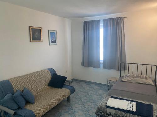 una sala de estar con un sofá y una cama en Apartma Bossamarino, en Koper