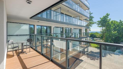 a balcony of a house with glass railing at Apartamenty Helski Brzeg in Hel