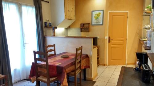 une cuisine avec une table et des chaises dans une pièce dans l'établissement Logement tranquille et frais proche gare au RDC, à Saumur