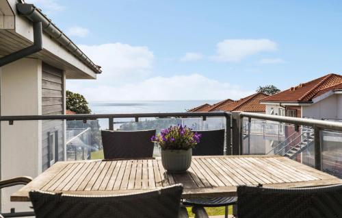 a wooden table on a balcony with a view of the ocean at Gudhjem Søpark Lejl 28 in Gudhjem